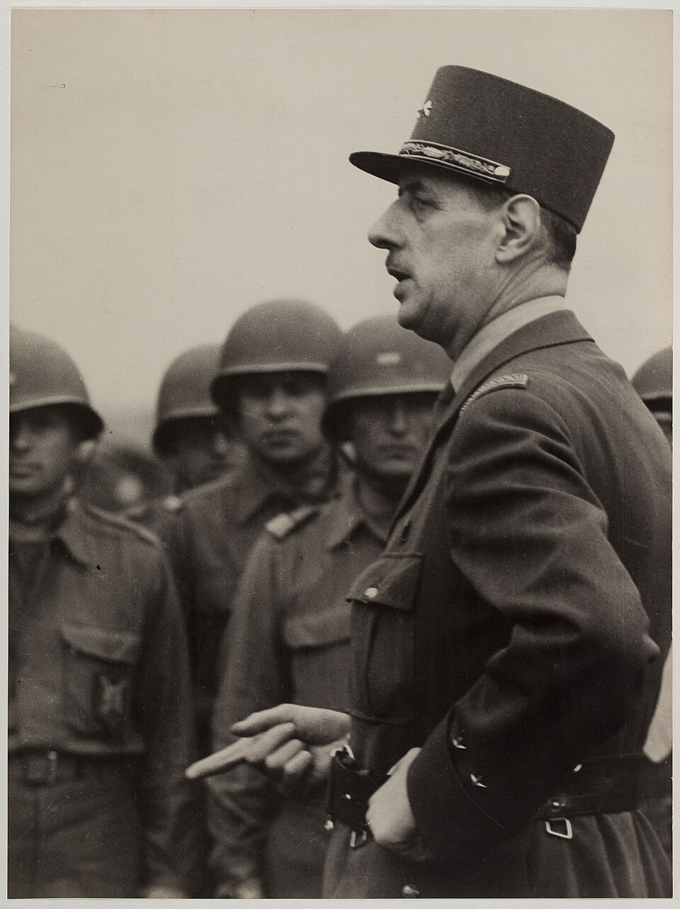 Charles de Gaulle devant des soldats casqu&eacute;s